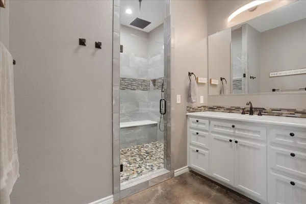 a bathroom with a shower sink and mirror