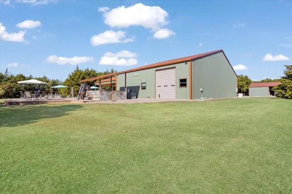 a view of a house with a big yard and large trees