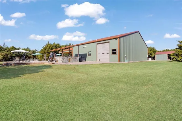 a view of a house with a big yard and large trees