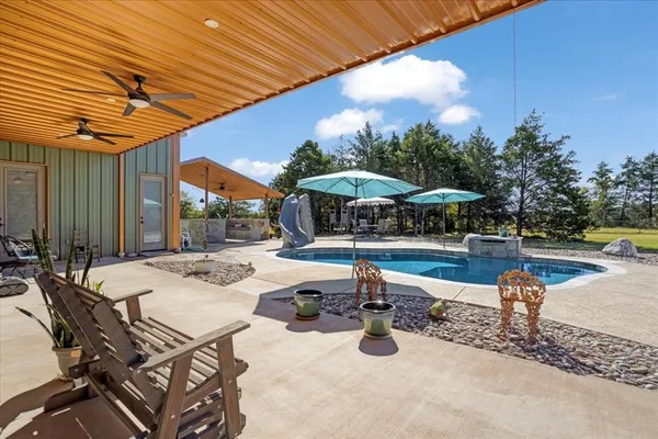 a view of a patio with a table and chairs under an umbrella