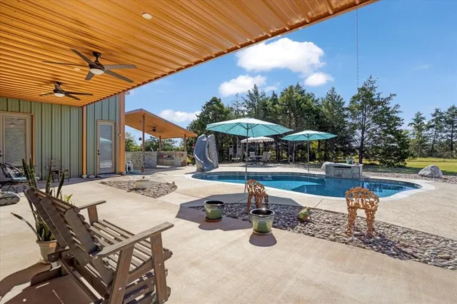 a view of a patio with a table and chairs under an umbrella