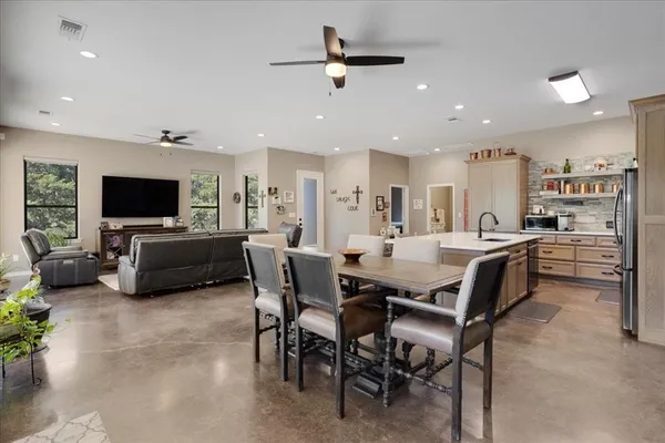 a living room with furniture a flat screen tv and a kitchen