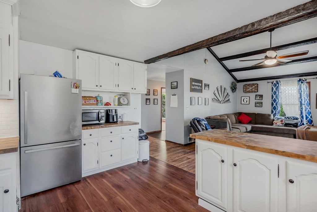 209 Lankford Road Cookeville, TN 38506 - Photo 14 of 38 a kitchen with granite countertop a refrigerator a sink dishwasher and white cabinets with wooden floor