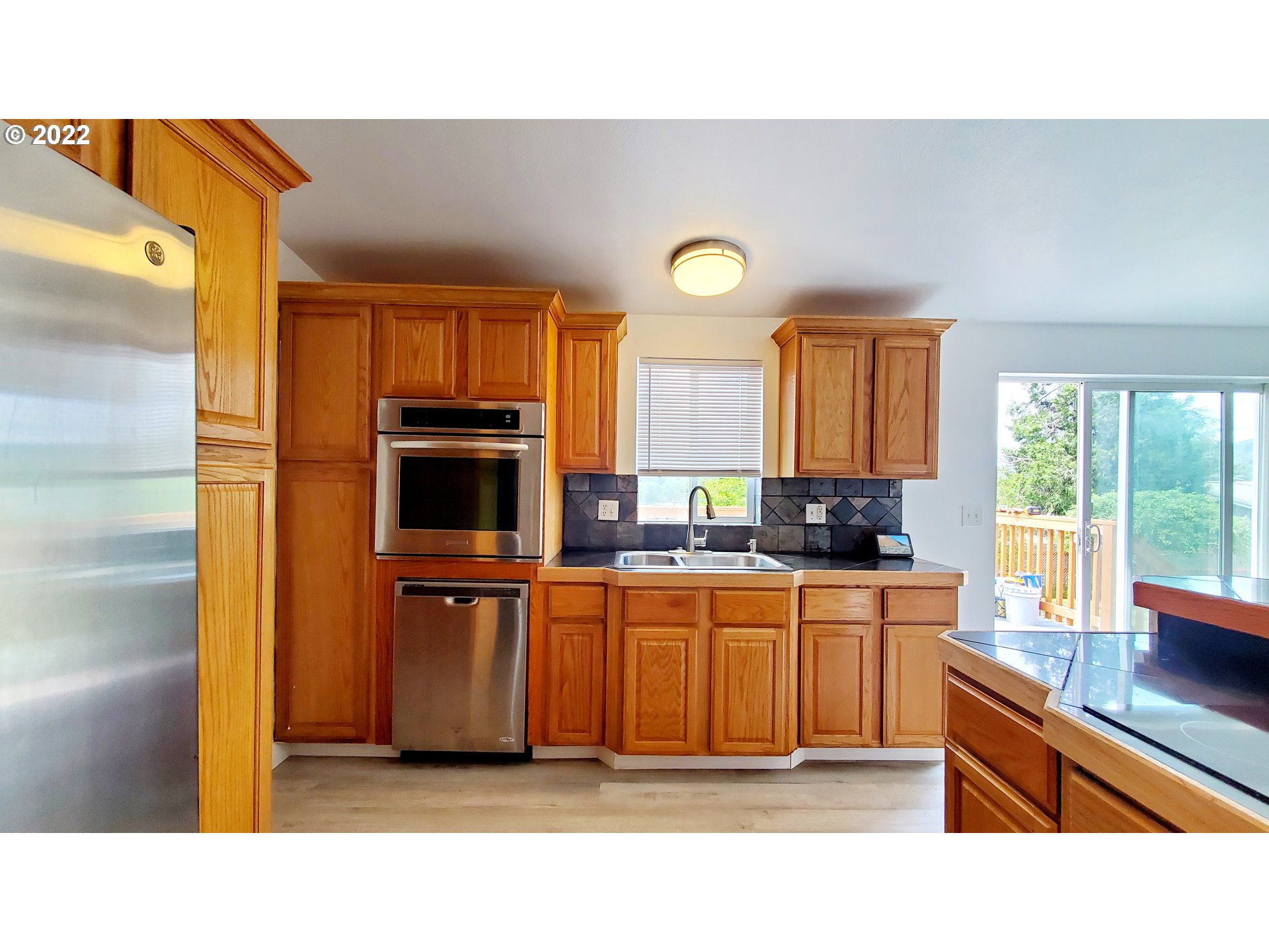 156 Oak Street Riddle, OR 97469 - Photo 14 of 23 a kitchen with stainless steel appliances a stove a sink and a microwave