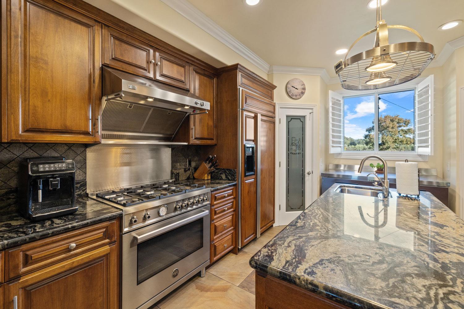 5288 West Kile Road Lodi, CA 95242 - Photo 24 of 45 a kitchen with granite countertop a stove and a refrigerator
