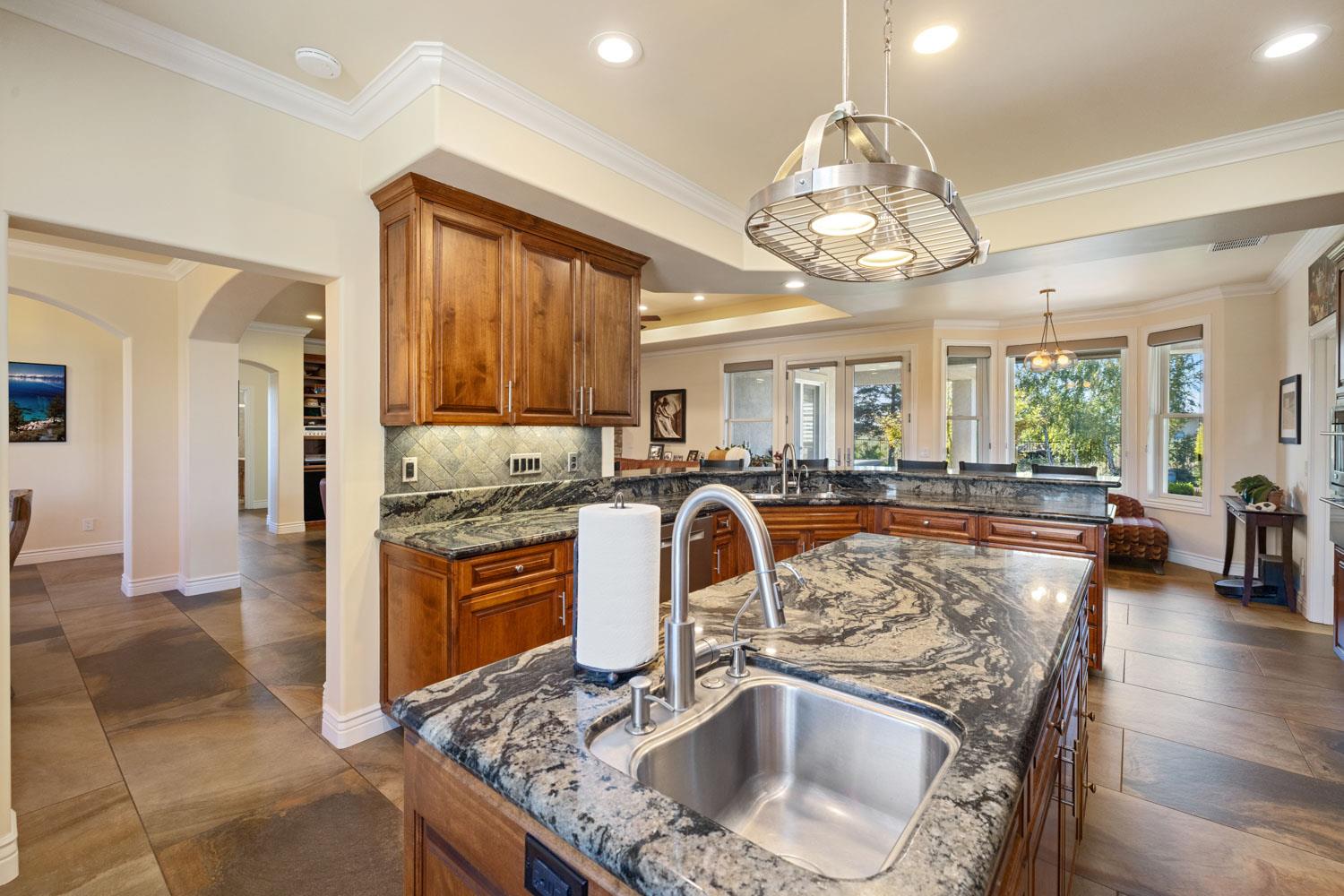 5288 West Kile Road Lodi, CA 95242 - Photo 26 of 45 a kitchen with kitchen island granite countertop a sink stainless steel appliances cabinets and furniture