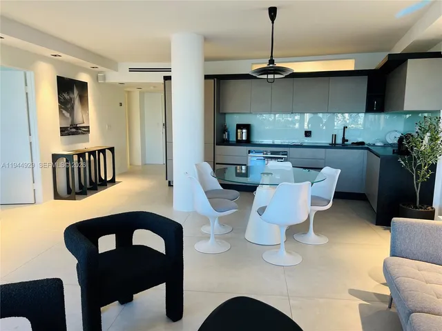 a kitchen with a table chairs and a refrigerator