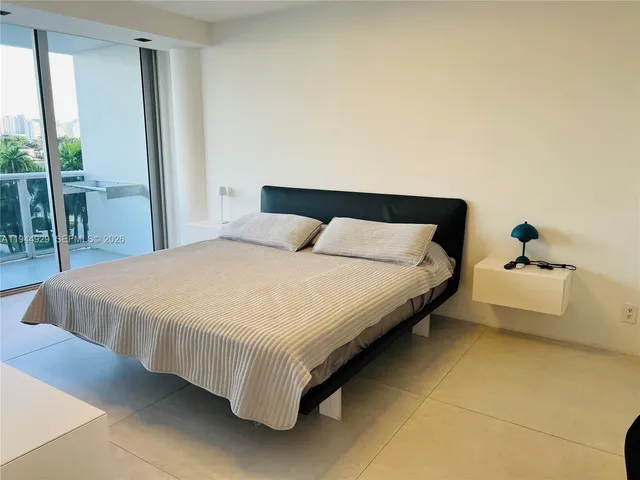 a large bed sitting in a bedroom next to a window