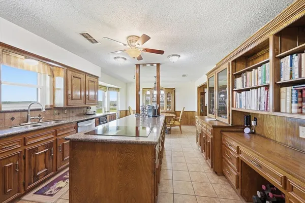a very nice looking living room with a large window and a book shelf