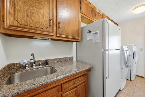 a kitchen with stainless steel appliances granite countertop a refrigerator and a sink