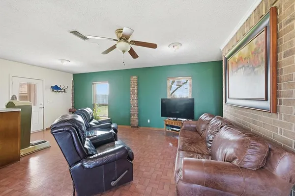 a living room with furniture ceiling fan and a window