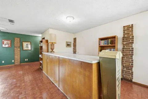 a view of a hallway with wooden floor and cabinet