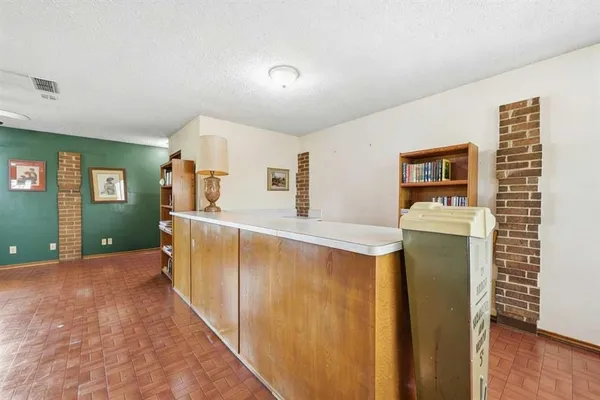 a view of a hallway with wooden floor and cabinet
