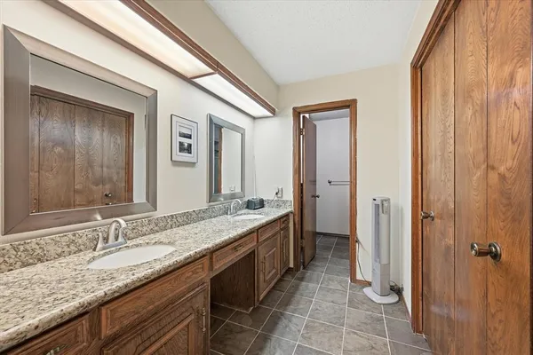 a bathroom with a granite countertop sink and a mirror