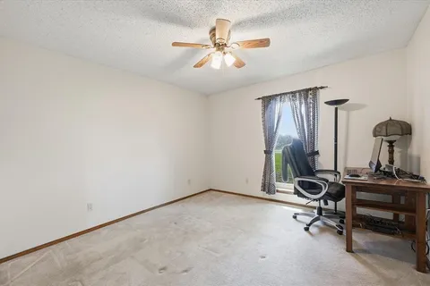 a view of a workspace with furniture and a window