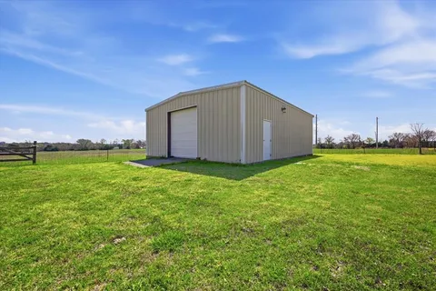 a house with green field in front of it