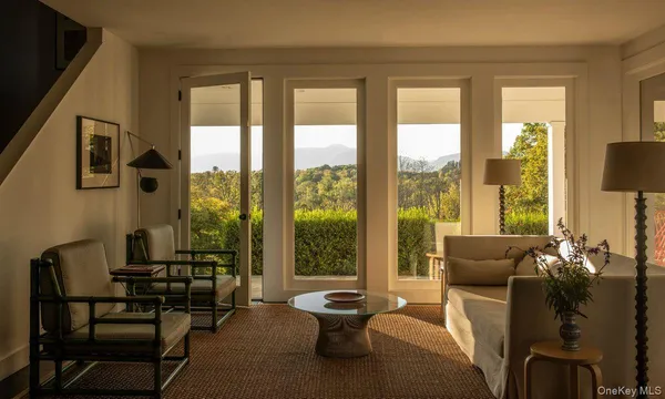 a living room with furniture and a floor to ceiling window