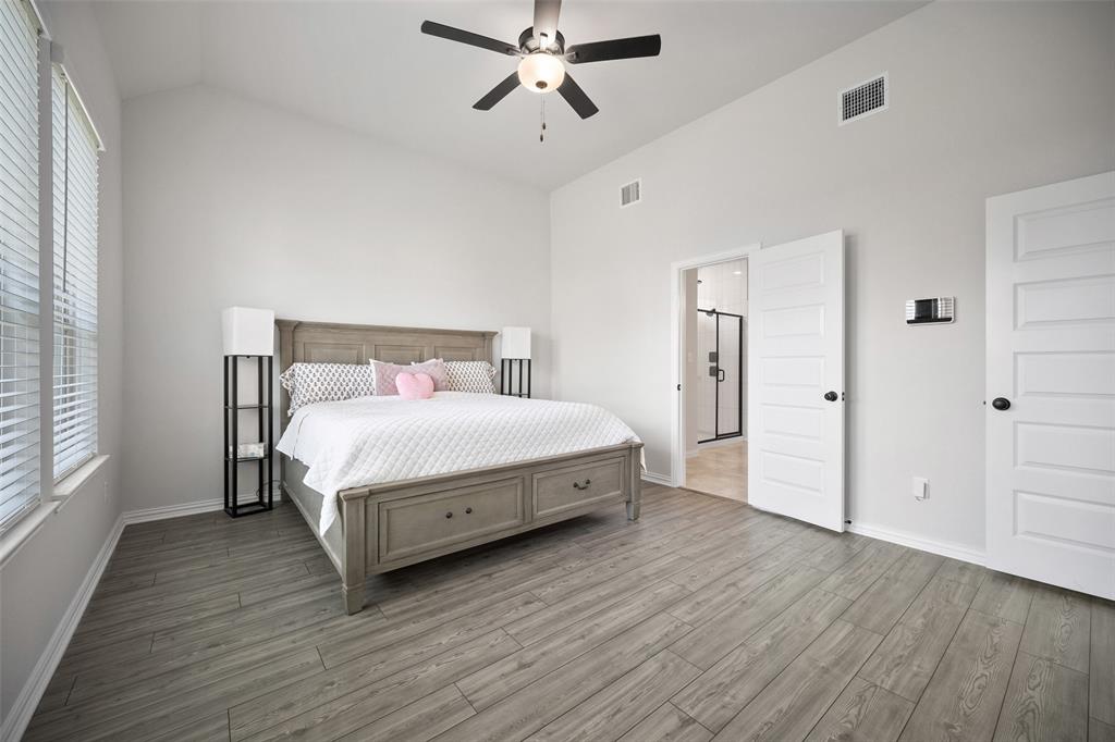 265 Fawn Riv Run Kyle, TX 78640 - Photo 14 of 39 High vaulted ceilings and wood-look flooring define this relaxing main-level bedroom suite.