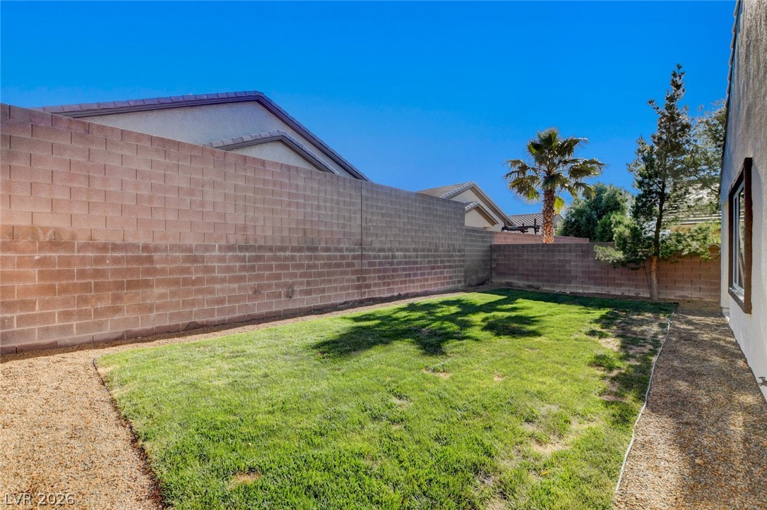 2649 Rue Marquette Avenue Henderson, NV 89044 - Photo 54 of 55 A well-maintained lawn within a private backyard, bordered by a sturdy block fence.