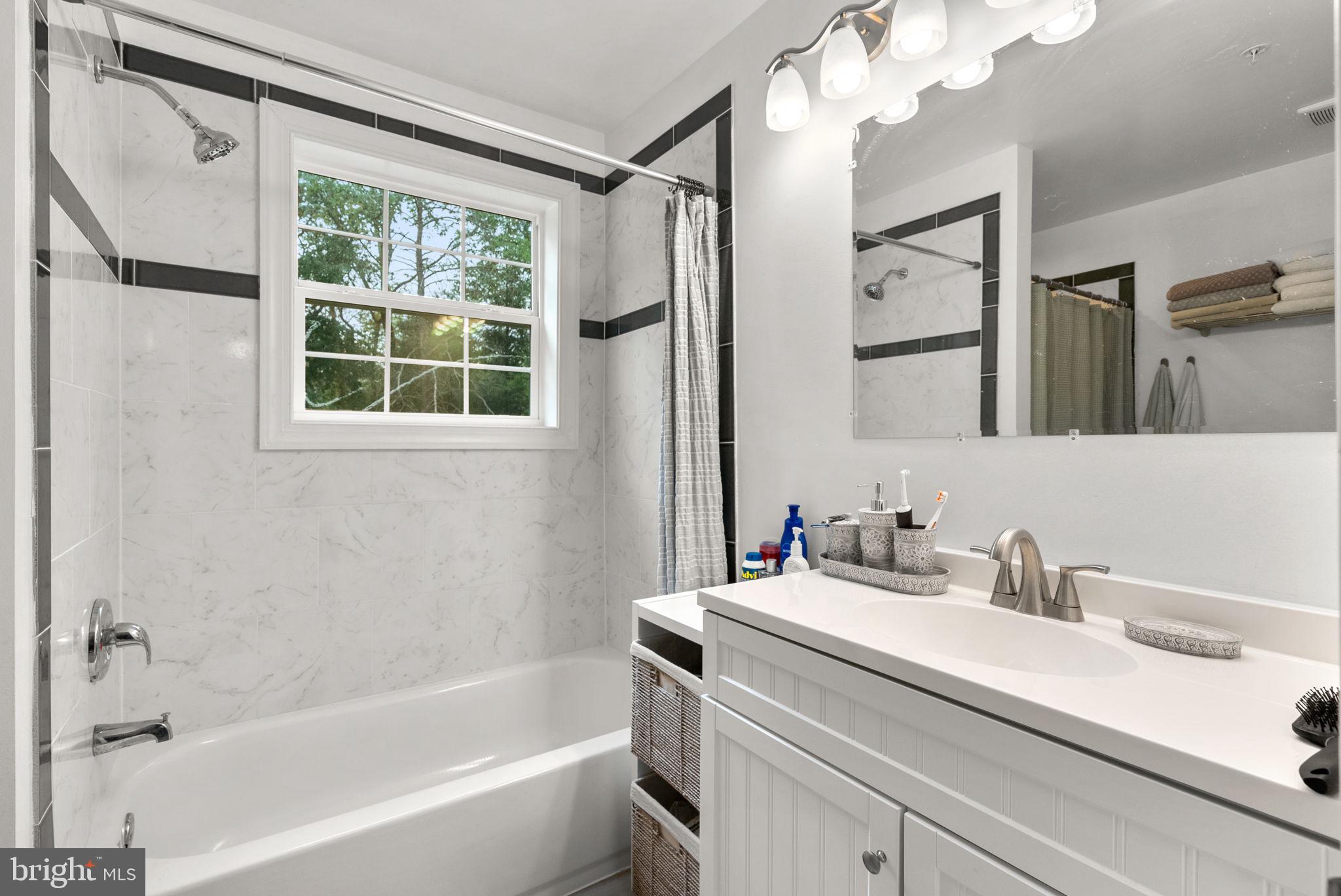 9621 Temple Hill Road Clinton, MD 20735 - Photo 28 of 48 a bathroom with a sink a large mirror and a bathtub with shower