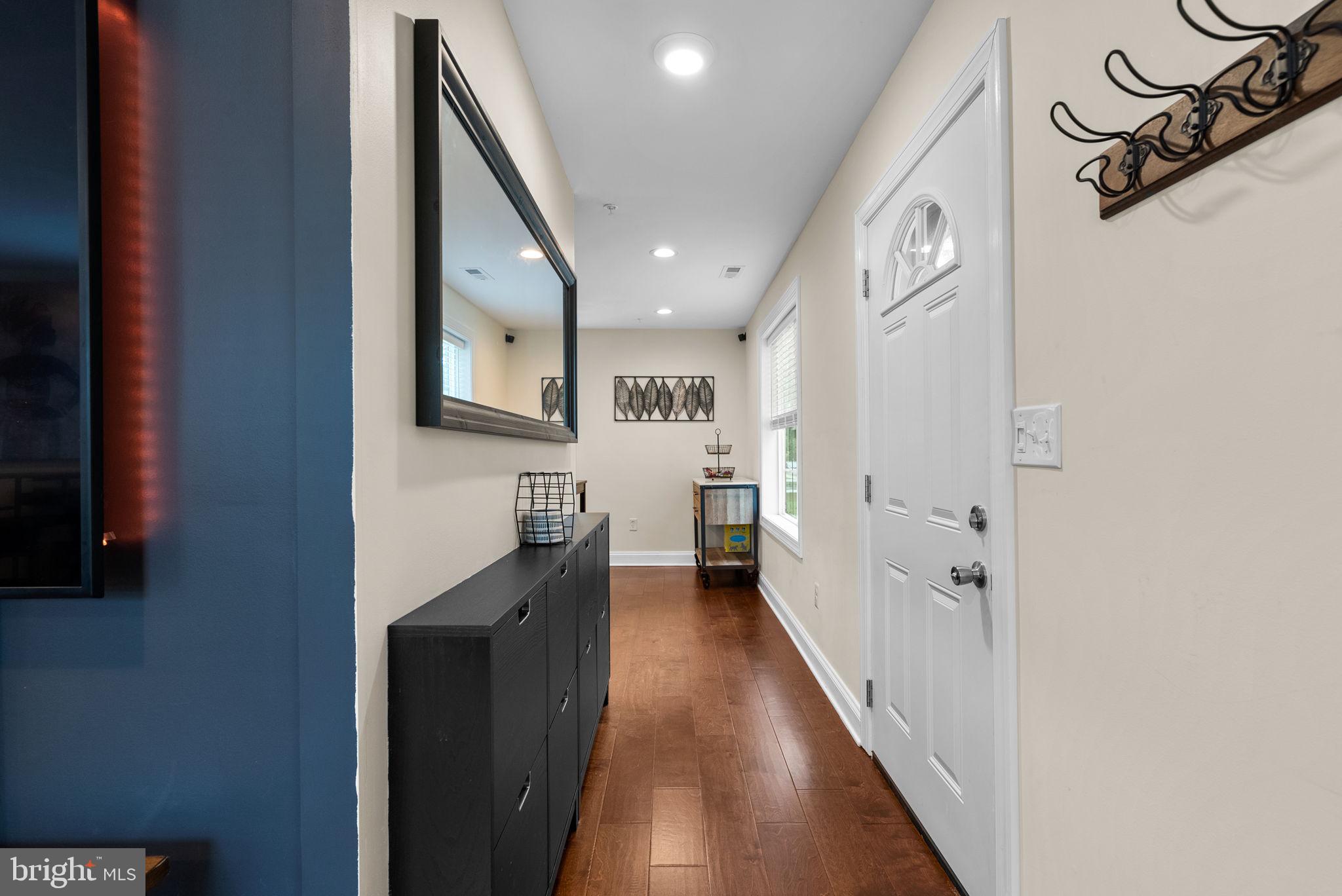 9621 Temple Hill Road Clinton, MD 20735 - Photo 5 of 48 a hallway with mirror and a wooden floor