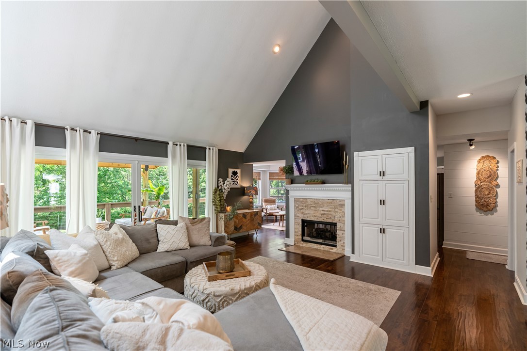 3228 Bancroft Road Akron, OH 44333 - Photo 17 of 50 Living room featuring high vaulted ceiling, a stone fireplace, dark hardwood / wood-style flooring, and a healthy amount of sunlight