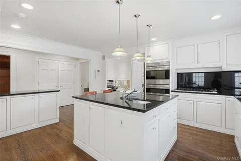 a kitchen with stainless steel appliances granite countertop a sink a stove and a wooden floors
