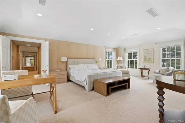 a spacious bedroom with a bed a table and chairs