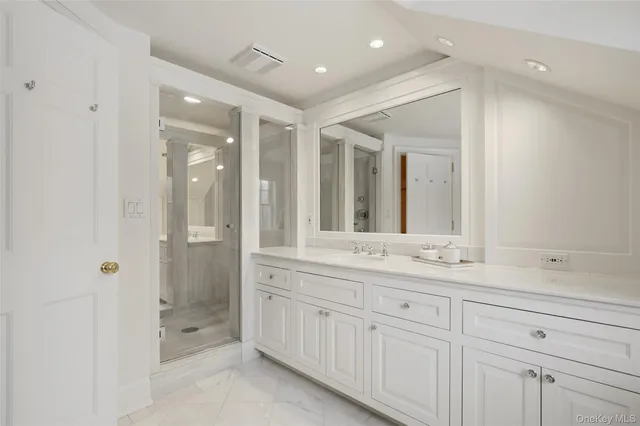 a bathroom with a shower sink and mirror