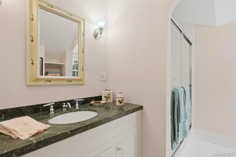 a bathroom with a granite countertop sink and a mirror