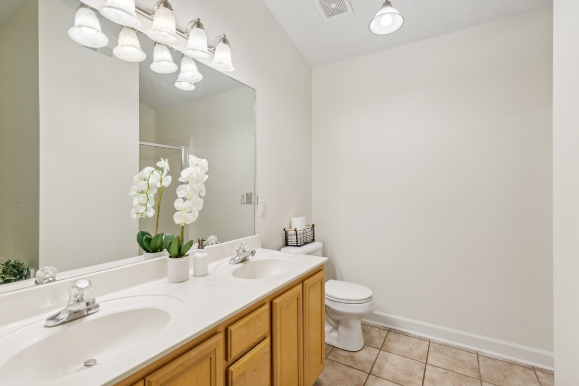 1948 Portway Road Spring Hill, TN 37174 - Photo 24 of 29 a bathroom with a granite countertop sink a toilet and a mirror