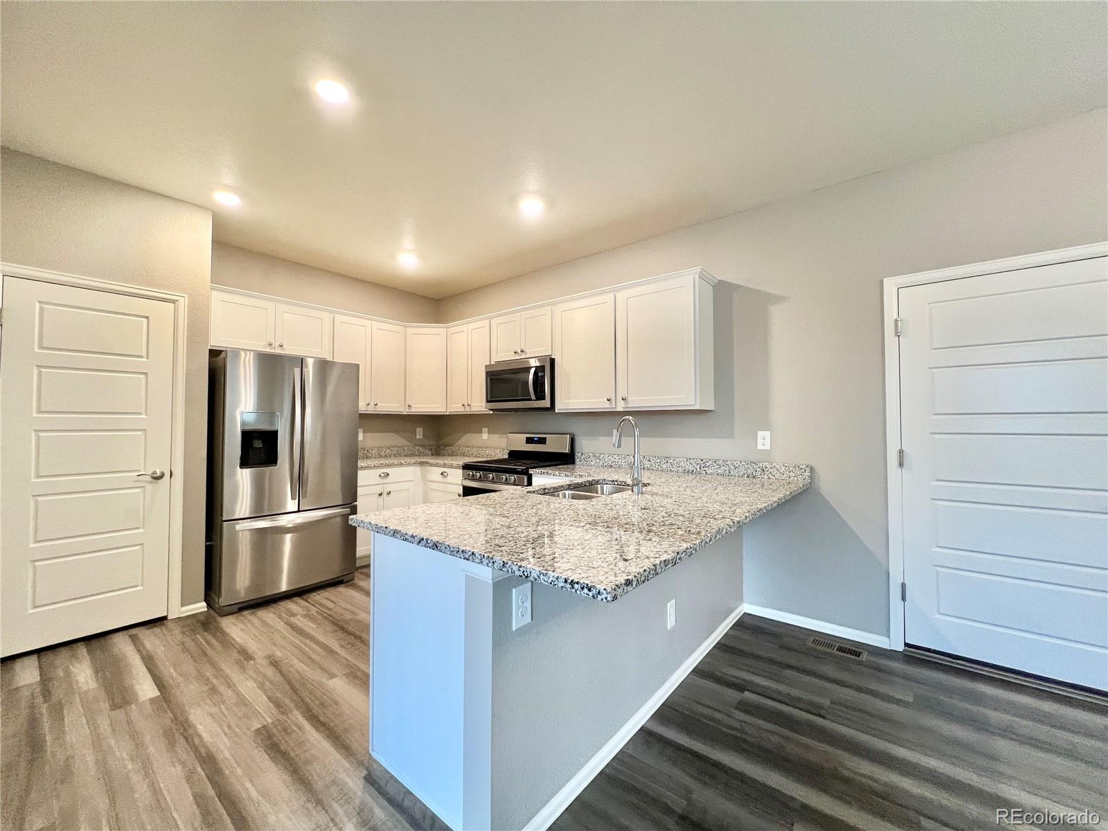 6902 Longpark Drive Parker, CO 80138 - Photo 4 of 18 a kitchen with stainless steel appliances granite countertop a refrigerator and a stove top oven