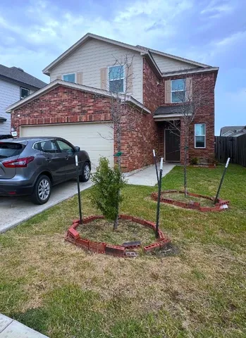 a view of a house with a yard and parking space
