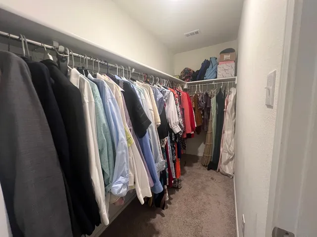 a view of walk in closet with clothes