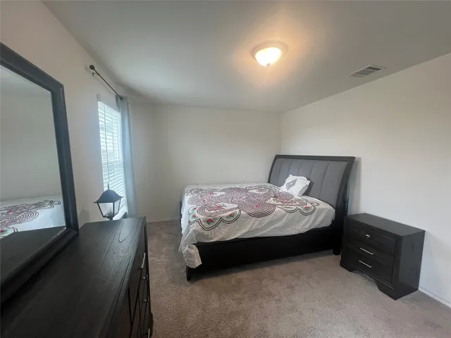 a bedroom with a bed and a mirror