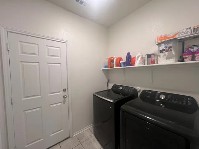 a utility room with dryer washer and shoe rack