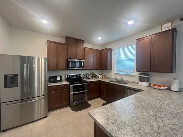 a kitchen with granite countertop stainless steel appliances and wooden cabinets