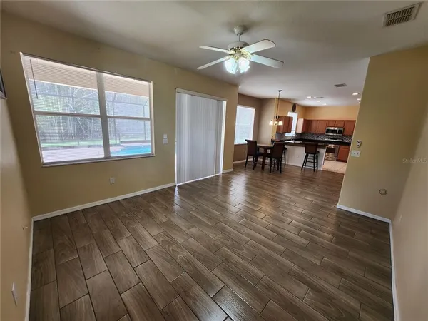 an empty room with wooden floor and chandelier