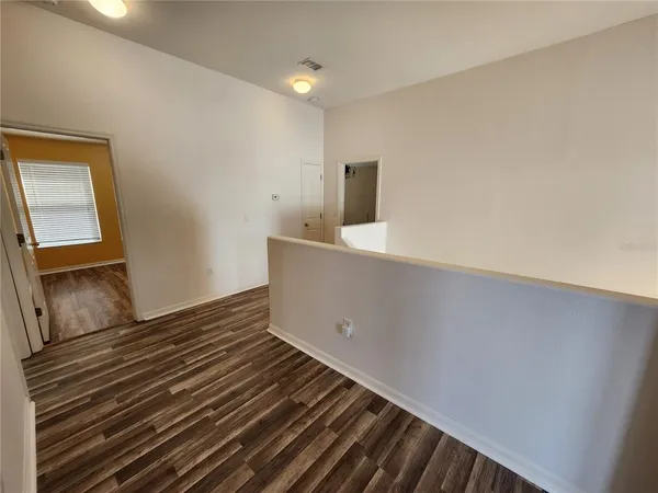 a view of an empty room and wooden floor