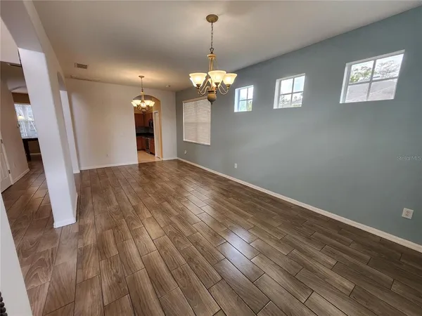 a view of a room with wooden floor and chandelier