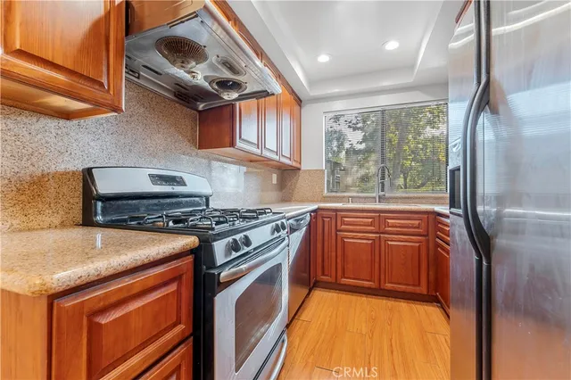 a kitchen with stainless steel appliances granite countertop a stove and a refrigerator