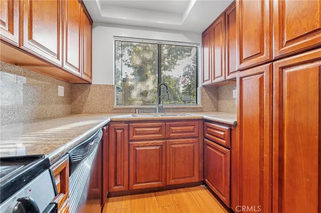 a kitchen with stainless steel appliances granite countertop a refrigerator a sink and wooden cabinets
