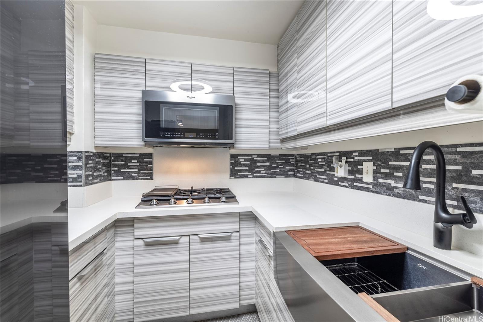 a kitchen with a stove and a white wooden cabinets
