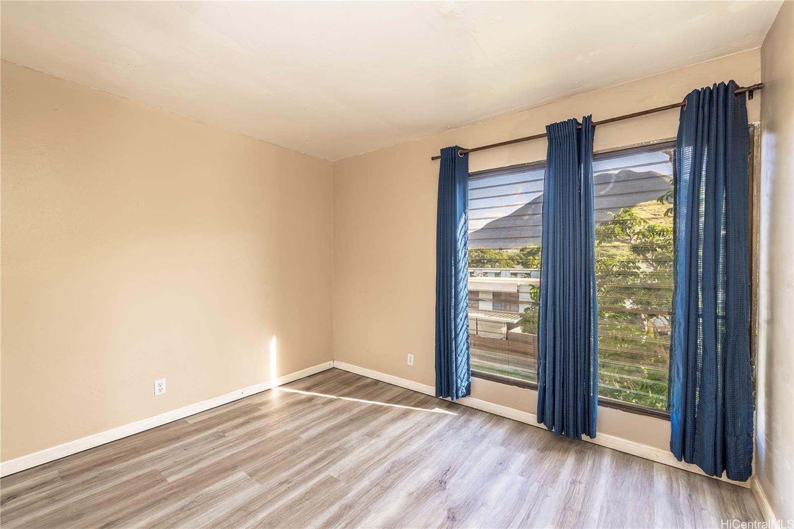 87-131 Helelua Street, Unit J304 Waianae, HI 96792 - Photo 11 of 19 a view of an empty room with wooden floor and a window