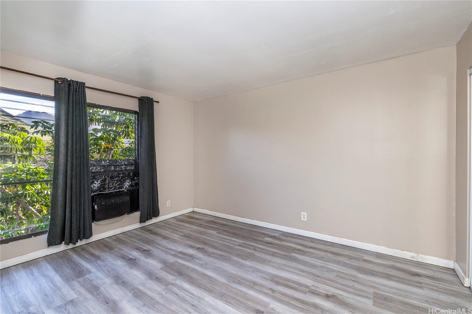 87-131 Helelua Street, Unit J304 Waianae, HI 96792 - Photo 14 of 19 wooden floor in an empty room with a window