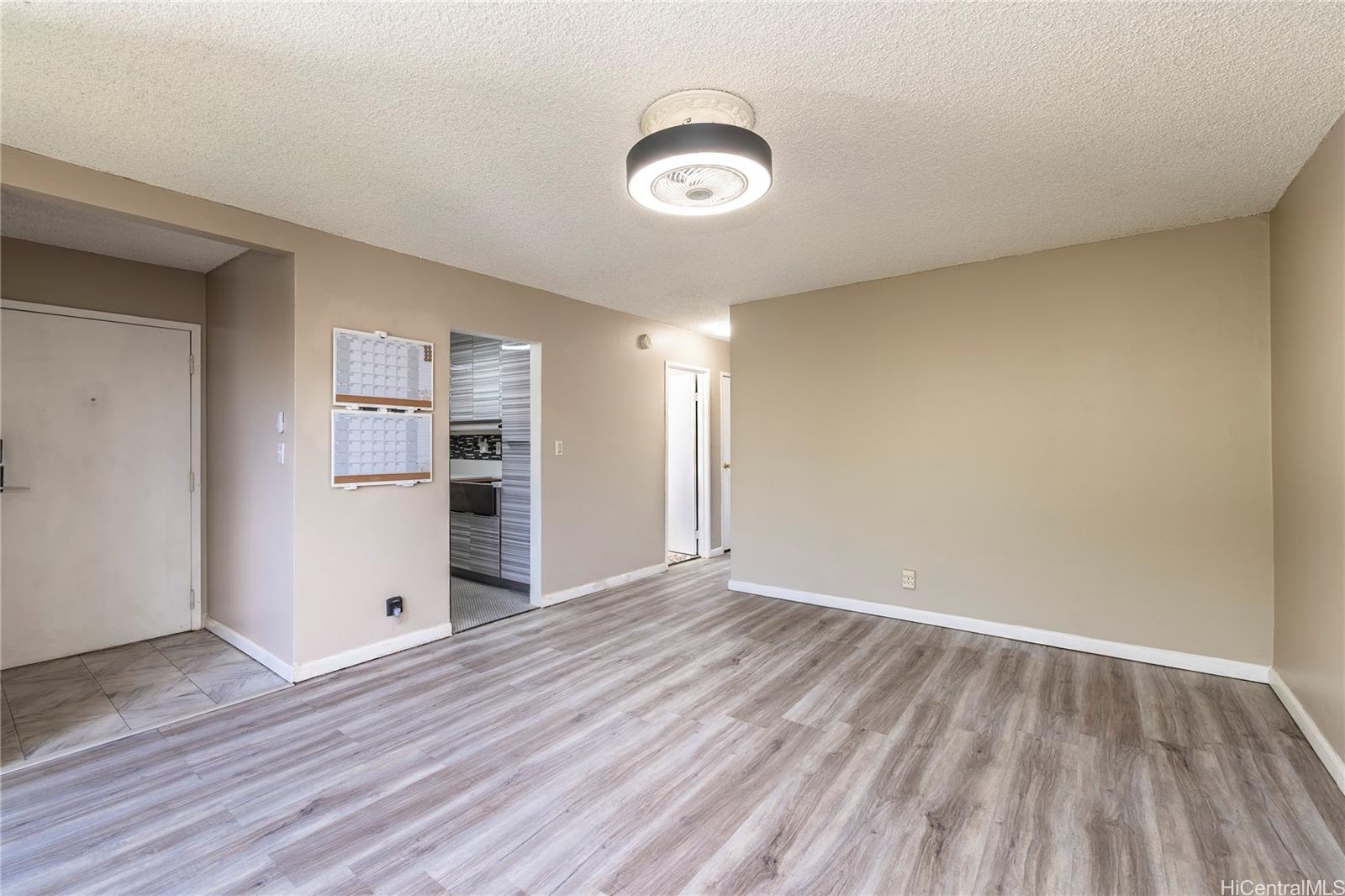 87-131 Helelua Street, Unit J304 Waianae, HI 96792 - Photo 3 of 19 an empty room with wooden floor and windows