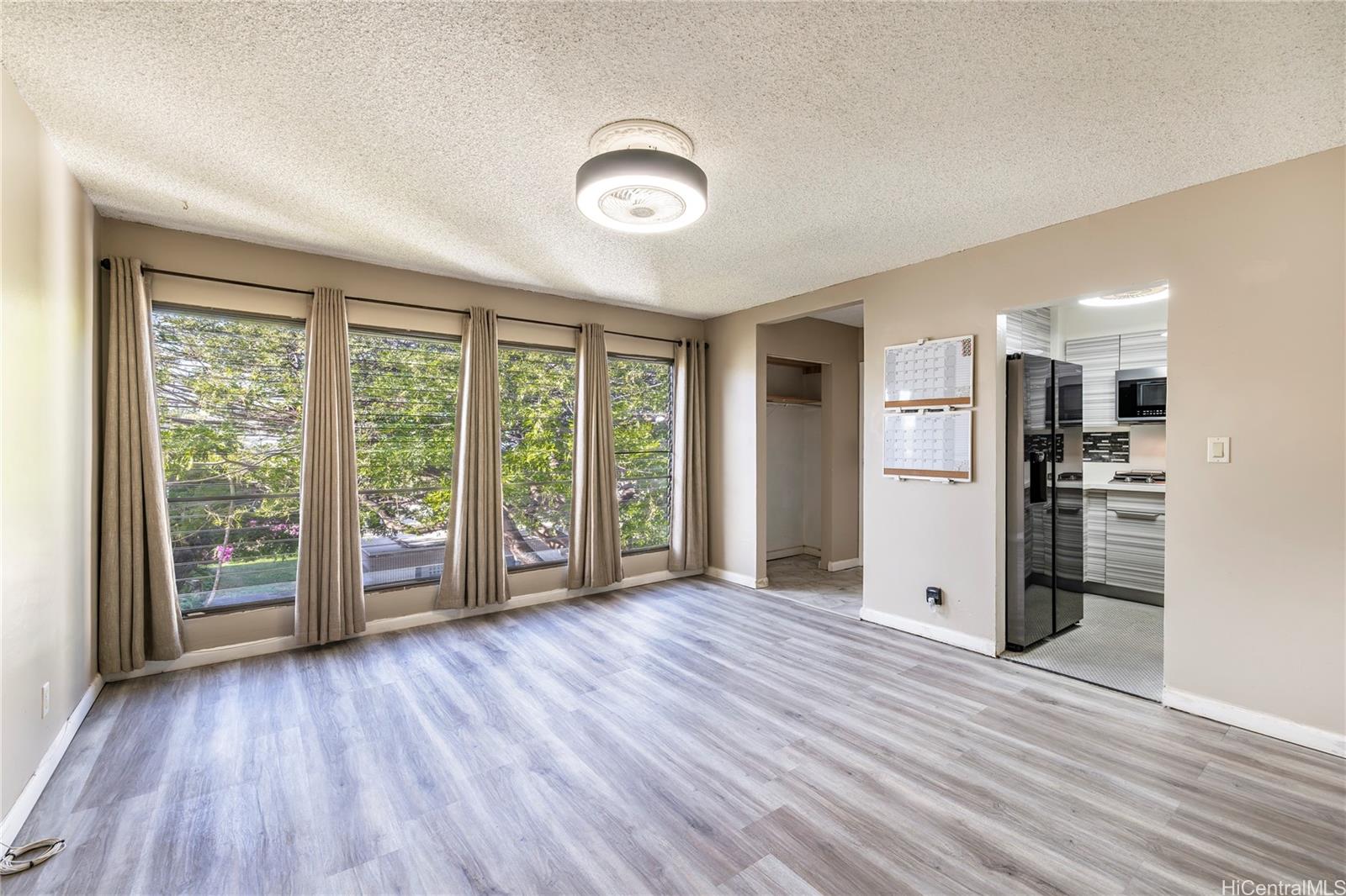 87-131 Helelua Street, Unit J304 Waianae, HI 96792 - Photo 5 of 19 a view of a kitchen with wooden floor and a large window