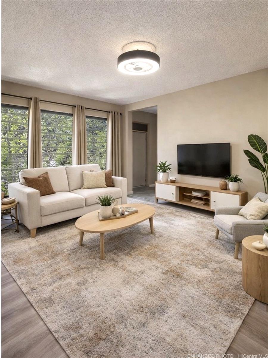 87-131 Helelua Street, Unit J304 Waianae, HI 96792 - Photo 6 of 19 a living room with furniture and a flat screen tv