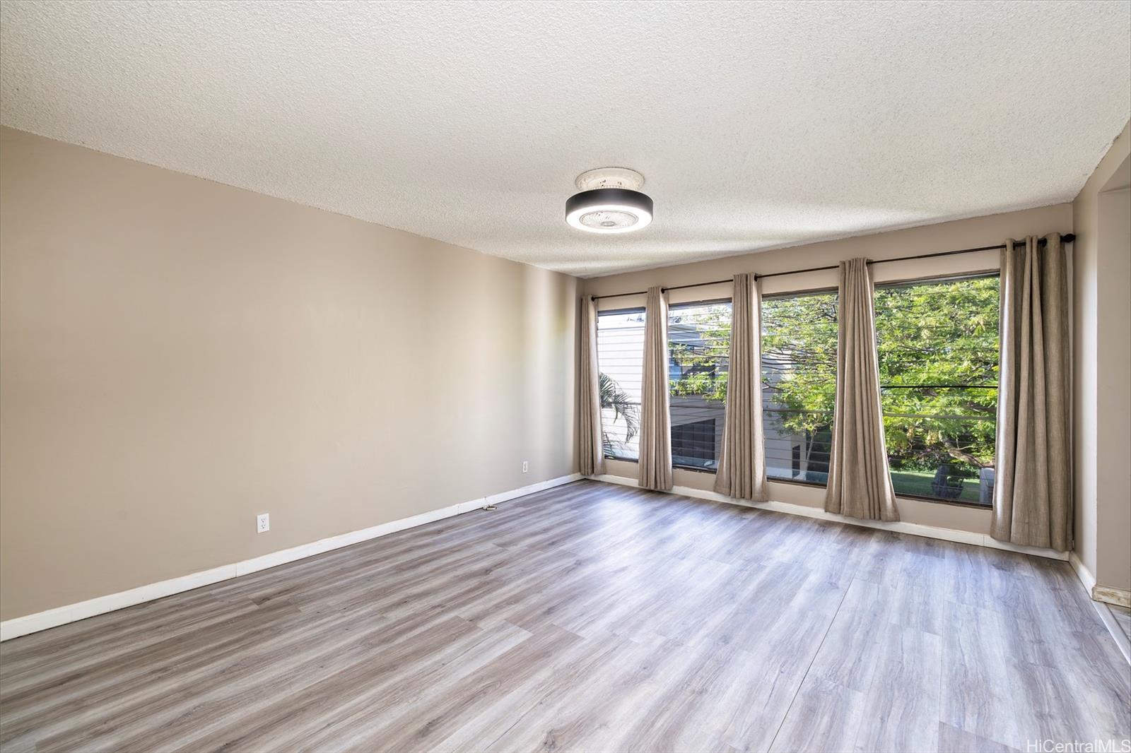 87-131 Helelua Street, Unit J304 Waianae, HI 96792 - Photo 7 of 19 an empty room with wooden floor and windows