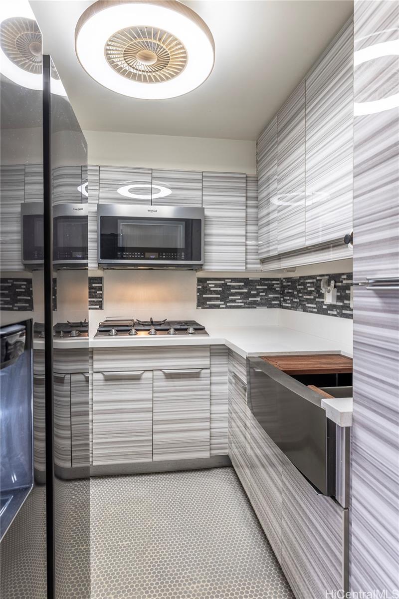 87-131 Helelua Street, Unit J304 Waianae, HI 96792 - Photo 8 of 19 a kitchen with a stove and a microwave